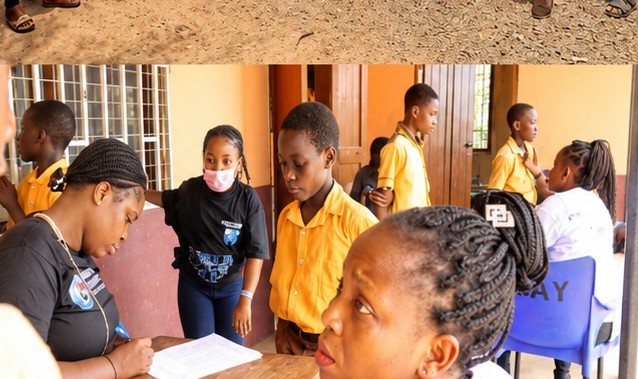 A volunteer registering schoolchildren at a desk