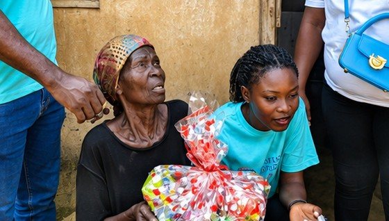 An elderly woman receiving a gift at Kpando Dafor