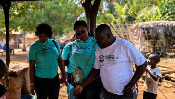 Volunteers presenting a gift to a family