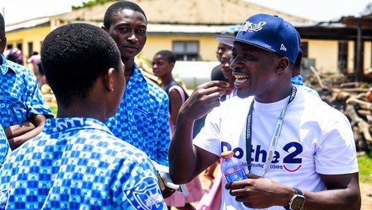 A Dotha2 volunteer speaking with a student