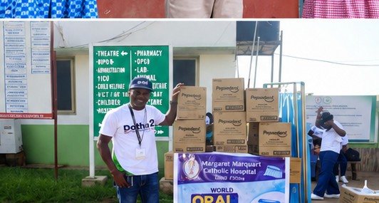Boxes of dental supplies beside the World Oral Health Day banner